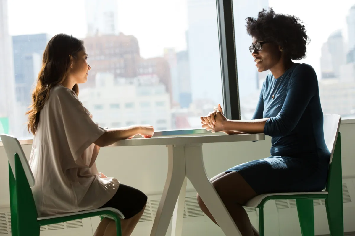 Two women conversing in a cafe
