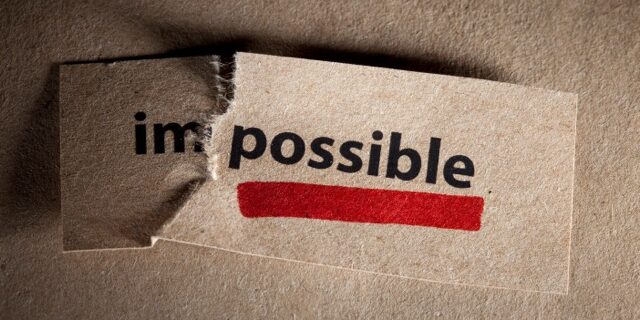 Piece of paper with the word 'Impossible' torn after the 'Im' to read 'possible' underlined in red.
