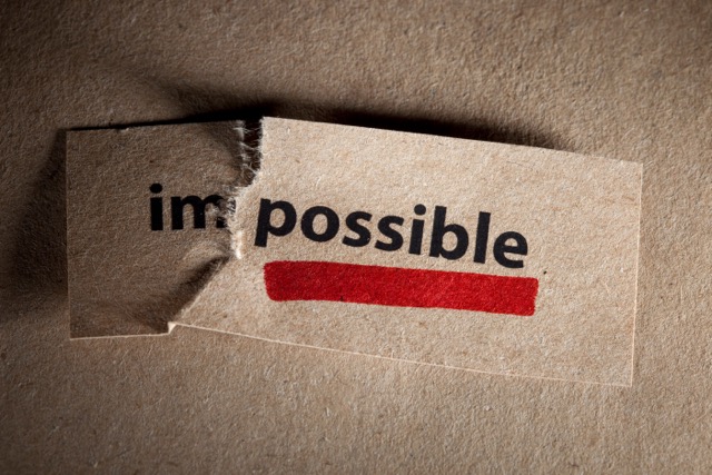 Piece of paper with the word 'Impossible' torn after the 'Im' to read 'possible' underlined in red.