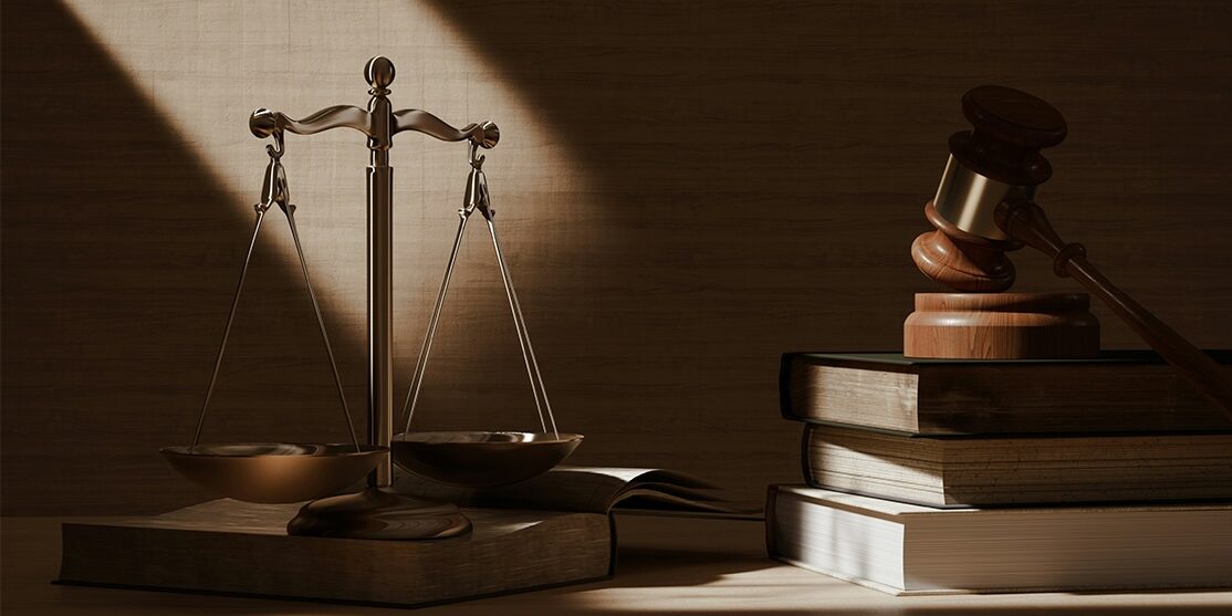 Justice Sytem Image of justice scales and a gavel on a stack of books.