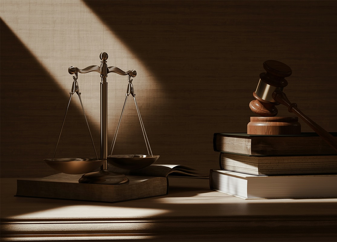 Image of justice scales and a gavel on a stack of books.