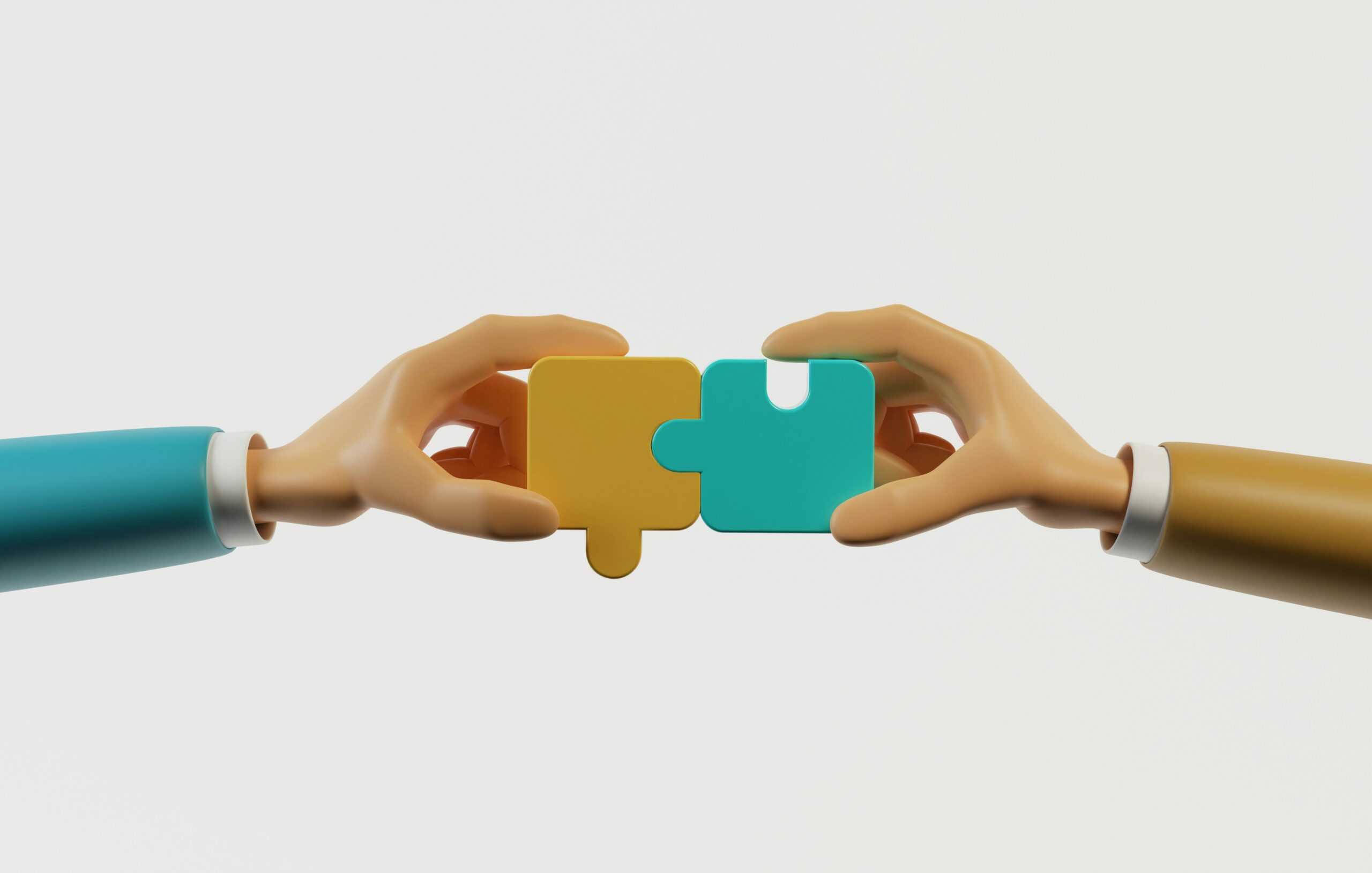 Two hands meeting by putting two puzzle pieces together.
